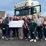 Daoine a bhí i láthair ag ócáid Tigh Nan Dooley nuair a bronnadh seic orthu ón seó bóthair a bhí ar bun faoi Nollaig.