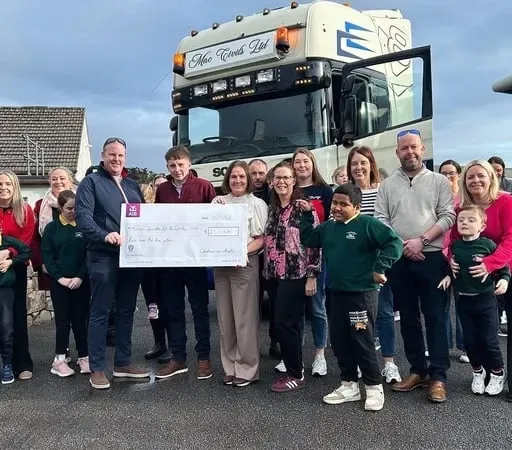 Daoine a bhí i láthair ag ócáid Tigh Nan Dooley nuair a bronnadh seic orthu ón seó bóthair a bhí ar bun faoi Nollaig.